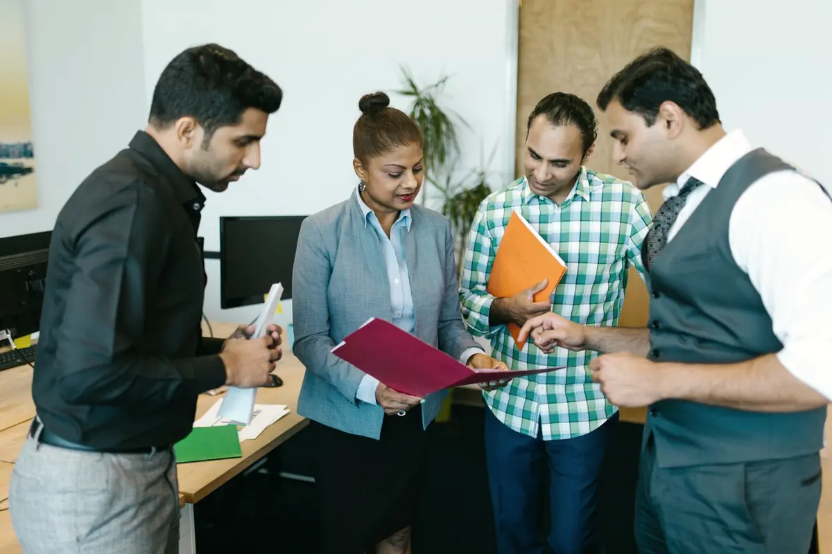 Four colleagues going over a folder together